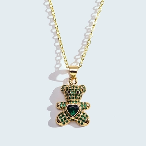 Detail of bear pendant featuring green pave zircon and heart-shaped gemstone center