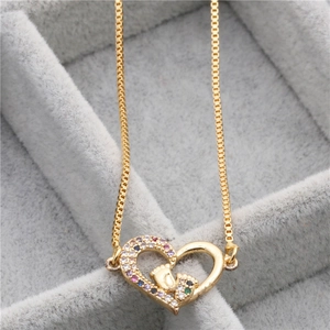 Golden heart necklace with colorful zircon stones and paw print in a velvet jewelry box