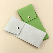 Detail view of suede PU makeup brush pouches in grey and green with snap closure