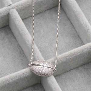 Macro shot of a silver shell pendant with micro-pave zircons on a delicate box chain