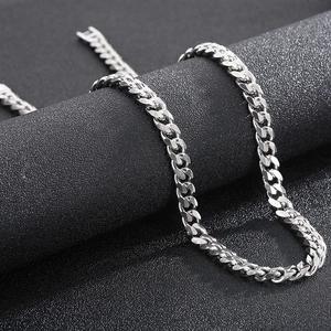Close-up of polished silver titanium steel Cuban link chain on a black background