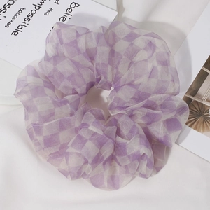 Detailed close-up of large purple checkered organza scrunchie with sheer texture