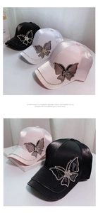 Detail of satin baseball caps in black, white, and pink featuring rhinestone butterflies