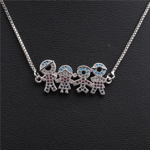 Macro shot of silver family pendant necklace with red and blue zircon on black leather