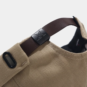 Close-up of khaki herringbone fabric texture and leather strap with star buckle