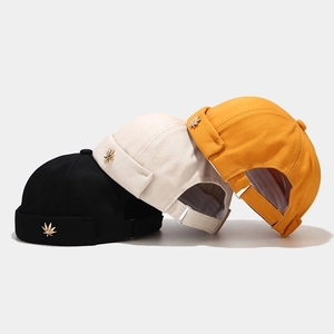 Detailed view of miki hats in black, beige and yellow with maple leaf embroidery
