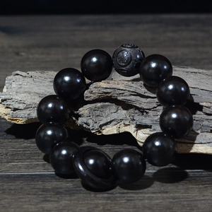 Détail macro de perles de prière de 20 mm en bois de santal noir avec gravure