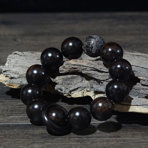 Détail macro de perles en ébène de 20mm avec mantra gravé à six caractères