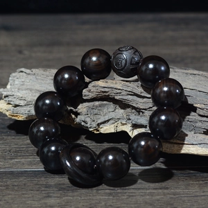 Détail macro de perles en bois de santal noir de 20 mm avec gravure de Bouddha