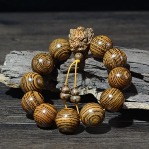 Détail des perles en bois de tigre de 20mm avec pendentif en forme de dragon