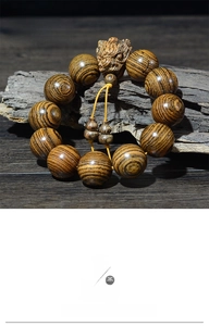 Vue détaillée du bracelet en bois de santal peau de tigre avec perle tête de dragon.
