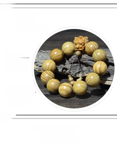 Détail macro du bracelet en bois de santal avec perle sculptée et texture naturelle