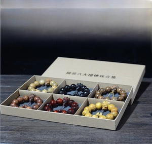 Détail de six bracelets bouddhistes en bois de santal dans un coffret cadeau élégant