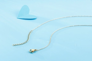 Detailed close-up of the lobster clasp and extension chain on the gold scorpion necklace