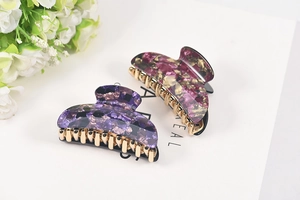 Close-up of purple and rose marble acetate hair claws with durable golden metal teeth