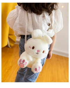Detail of cute white plush bunny crossbody bag with woven strap on a child back