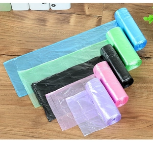 Detailed view of colorful disposable plastic trash bags in blue green pink and purple rolls