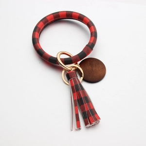 Detail van rood en zwart geruite polsband sleutelhanger met leren franje en houten hanger