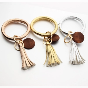 Three-piece bangle keychain set in gold, silver, and rose gold with leather tassels