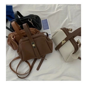 Flat lay of retro doctor-style handbags in black, brown, and coffee with gold clasps