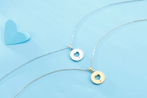 Detailed top view of gold and silver hollow heart necklaces with sparkling small crystals