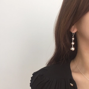 Minimalist S925 silver triple ball drop earrings worn by a model in a modern street style