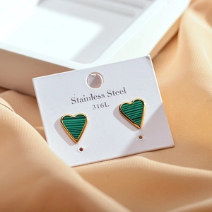 Macro shot of green striped heart earrings in 316L gold-plated stainless steel