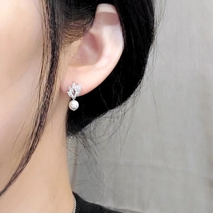 Leaf shaped zircon drop earrings with white pearls on model for elegant bridal look