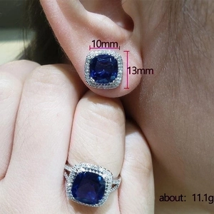 Elegant jewelry set with blue square glass earrings and ring worn by a model