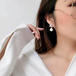 Baroque pearl earrings with sparkling leaf-shaped zircon decoration in bright silver finish