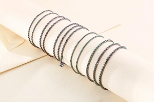 Close-up of rainbow stainless steel twist and box chains on a display stand