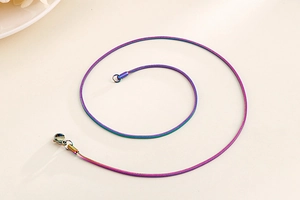 Macro detail of rainbow stainless steel round snake chain necklace with lobster clasp