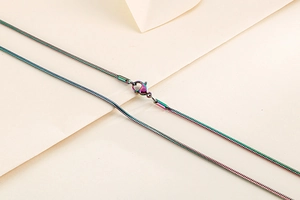 Detailed close-up of a rainbow-colored stainless steel snake chain with lobster clasp