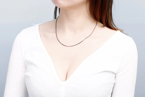 Polished stainless steel snake chain necklace shown on a model neck with a V-neck top