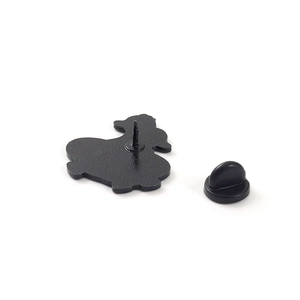 Rear view of cute cartoon duck enamel pin with black rubber clutch on white background