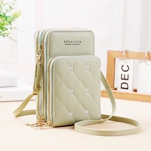 Detail of mint green crossbody phone bag with quilted rhombic pattern and butterfly embroidery