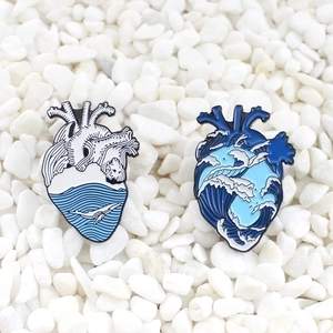 Creative enamel heart brooches with ocean wave designs and whale on white pebbles