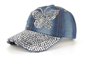 Close-up of butterfly rhinestone pattern and sparkling crystals on denim baseball cap