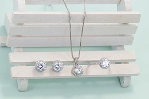 Classic silver jewelry set featuring a pendant necklace, earrings and ring with round crystals