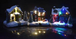 Detailed view of LED glowing Christmas miniature resin houses with snow effects and lights