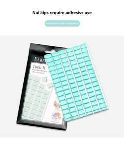 Close-up of mint green adhesive tack squares and packaging for nail art and office use