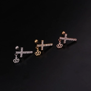 Detail of stainless steel ear studs with cross and crown pendants in three colors