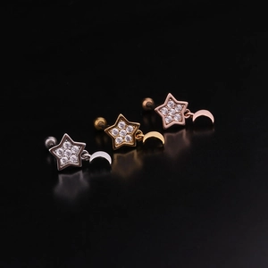 Close-up of star and moon screw back earrings in silver, gold and rose gold