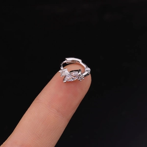 Silver cartilage hoop earring featuring marquise-cut zircon held on a fingertip