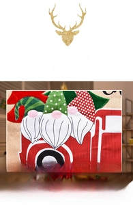 Detail of Christmas chair cover showing linen fabric with embroidered gnomes and red truck