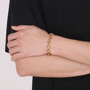 Close-up of golden knotted chain bracelet with chunky links on model wrist