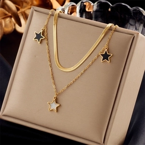 Close-up of double-layered gold necklace with star pendants on beige jewelry cushion