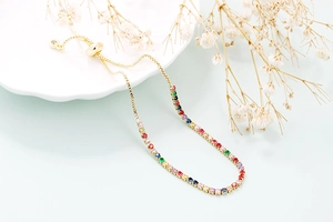 Detailed close-up of rainbow zircon tennis bracelet with gold finish and adjustable drawstring