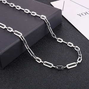 Close-up of a silver titanium steel paperclip chain necklace on a dark display box