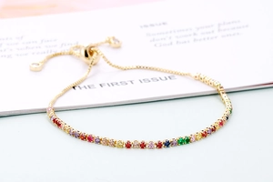 Close-up of golden rainbow zircon bracelet with adjustable pull closure on white background